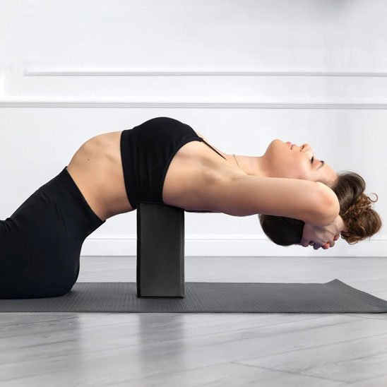 Brique yoga, femme étire son dos 