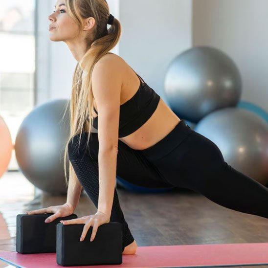 Brique yoga, femme pratique exercice de d'étirement en appuyant sur les brique de yoga