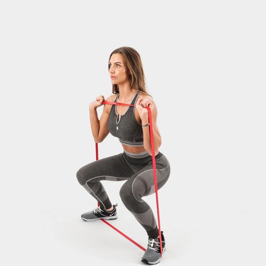  femme en position squate a l'aide de elastique musculation rouge résistance de 15 à  35 lbs