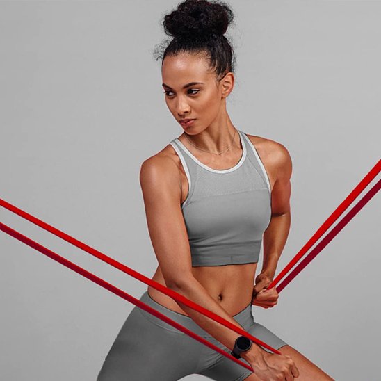 femme s'étire avec elastique musculation rouge resistance de 15 à 35 lbs