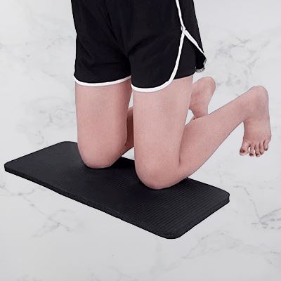 tapis de yoga noir :femme sur les genoux