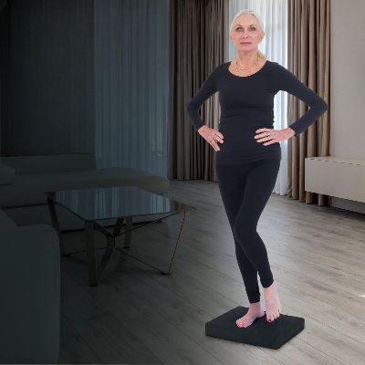 tapis yoga femme debout sur un pied et les mains sur les hanches
