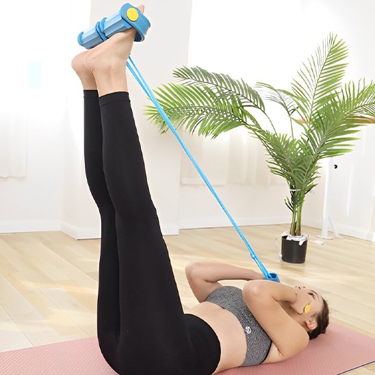 Une femme est allongée sur un tapis de yoga, les jambes levées, utilisant un Élastique musculation 