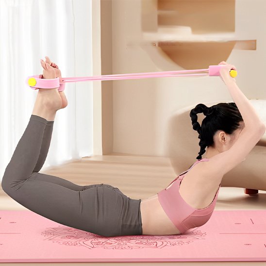 Une personne fait un exercice d’étirement au sol sur un tapis de yoga , en utilisant un élastique tenue entre les main et les pieds