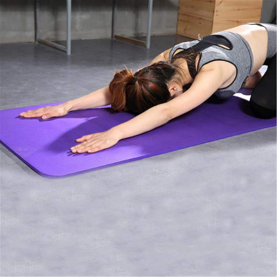 yogamats femme réalise la posture de l'enfant étendue 